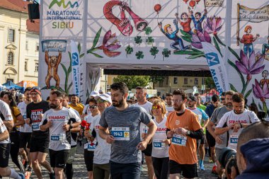 Sibiu City, Romanya - 25 Mayıs 2024. İnsanlar dışarıda spor yapıyor ya da granit küplerden yolda kardiyo eğitimi alıyorlar.