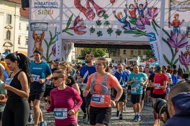 Sibiu City, Romanya - 25 Mayıs 2024. İnsanlar dışarıda spor yapıyor ya da granit küplerden yolda kardiyo eğitimi alıyorlar.