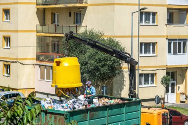 Sibiu City, Romanya - 27 Mayıs 2024. İşçiler konteynırları seçici çöplerle dolduruyor, sokak temizliği, çöpleri boşaltan adamlar.