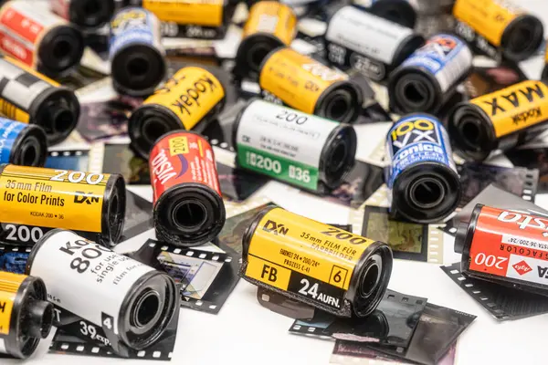 stock image Sibiu, Romania - April 07, 2024. Empty 35mm film canisters from developed film with old 35 mm film strips