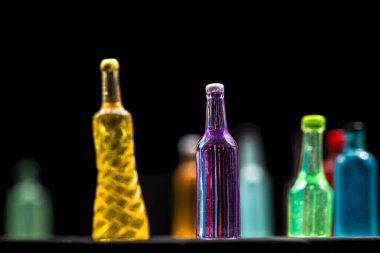 Siyah arka planlı etiketsiz çeşitli minyatür alkol şişeleri