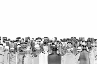 Beyaz arka planda etiketsiz çeşitli minyatür alkol şişeleri