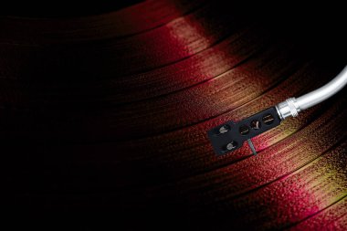Kırmızı Vinil plak, turntable kolu ile makro çekimde dönüyor