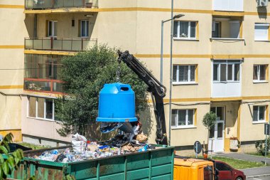 Sibiu City, Romanya - 27 Mayıs 2024. İşçiler konteynırları seçici çöplerle dolduruyor, sokak temizliği, çöpleri boşaltan adamlar.