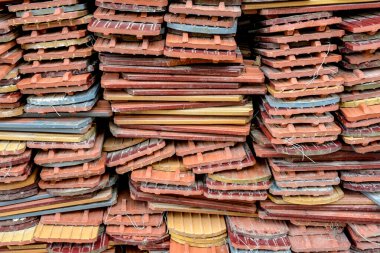 Bir yığın düzgün istiflenmiş kullanılmış kiremit.