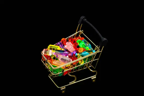 stock image Golden Shopping chart or supermarket trolley full with various miniature bottles of alcohol without labels with black bacground