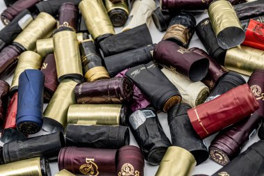 Sibiu, Romanya - 4 Ocak 2024. Alüminyum ve plastik şarap kapakları farklı şaraplardan üretiliyor.