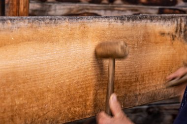 A man using two wooden mallets to beat a wooden semantron. A man using two wooden mallets to beat a wooden semantron clipart