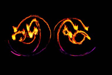 Ateşli güzel şekiller, büyüleyici bir görüntü, ışık boyası, bir gösteri sırasında Ateş Hareketi