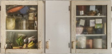 Mutfak için çeşitli ürünlerle dolu soluk kremalı kiler dolabı.