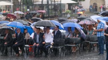 Sibiu City, Romanya - 11 Haziran 2024. Şiddetli bir yağmurun altında öğrencilerin şapkalarını havaya attıkları mezuniyet töreni.