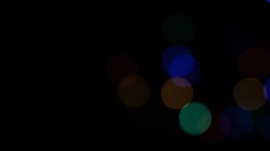 Disko partisindeki renkli bokeh ışıklandırması siyah arkaplan ile maviye boyandı 