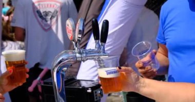 Sibiu City, Romanya - 25 Mayıs 2024. Barmen bardağı, yakın çekimden köpüklü birayla dolduruyor.
