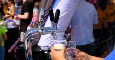 Sibiu City, Romanya - 25 Mayıs 2024. Barmen bardağı, yakın çekimden köpüklü birayla dolduruyor.