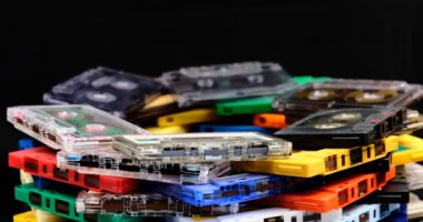 Eskimiş eski ses kasetleri koyu arkaplanı olan dönen bir masanın üzerinde