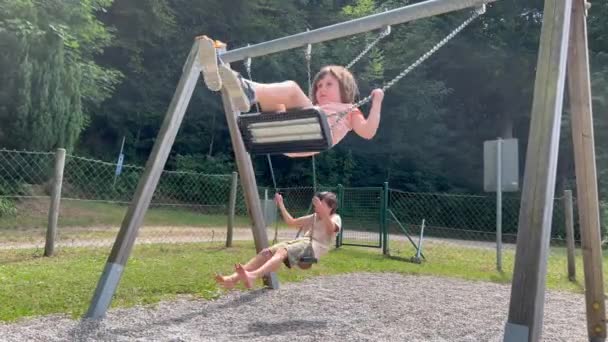 Αγόρι Και Κορίτσι Διασκεδάζουν Στην Κούνια Στο Πάρκο — Αρχείο Βίντεο