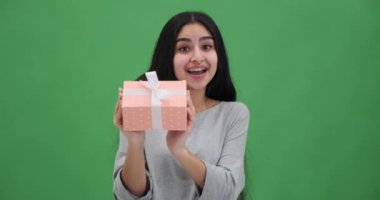 Gülümseyen genç kadın hediye kutusuyla bayram hediyesini paylaşıyor.