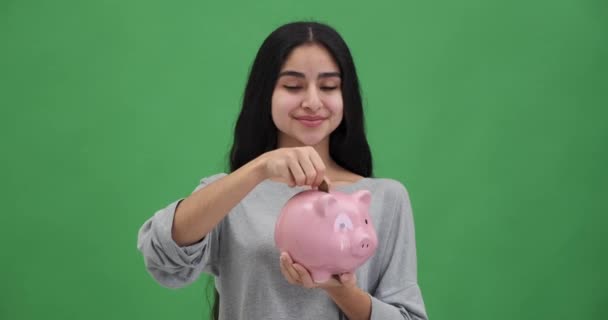 Ευτυχισμένη Νεαρή Γυναίκα Που Βάζει Κέρμα Στον Κουμπαρά Και Κάνει — Αρχείο Βίντεο
