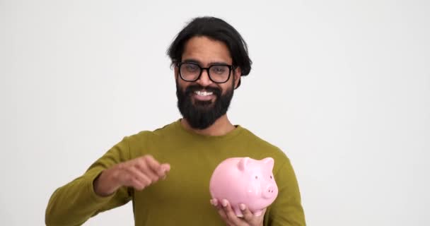 Портрет Веселого Бородатого Молодого Чоловіка Який Вставляє Монети Скарбничку Показує — стокове відео