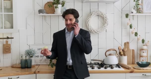 朝食を取り 家庭のキッチンで携帯電話で話すビジネスマン — ストック動画