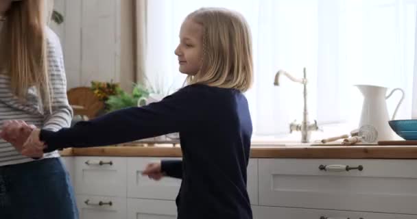 与妈妈一起在厨房里跳着金发碧眼的可爱而快乐的女儿的慢镜头 — 图库视频影像