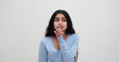 Komik kadın işaret parmağını dudaklarında tutuyor. Sessiz jest yapıyor.
