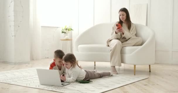 Мать Пишет Сообщения Мобильном Телефоне Диване Пока Дети Лежат Смотрят — стоковое видео