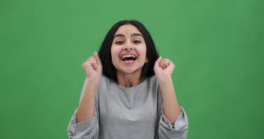 Coşkulu bir kadın başarıyı heyecanla dans ederek kutluyor.