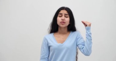 Genç bir kadın elleriyle vıdı vıdı jest yapıyor.