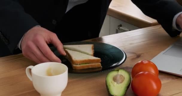 Zajęty Biznesmen Jedząc Śniadanie Pracując Laptopie Kuchni — Wideo stockowe