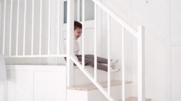 階段を滑り降りて家を這う女の子 — ストック動画
