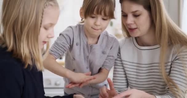 快乐的年轻妈妈周末在厨房里用面团做新鲜饼干 帮助可爱的女儿们聊天 — 图库视频影像