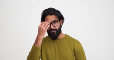 Yakışıklı sakallı genç adamın izole edilmiş beyaz arka planda poz verirken saçlarını ayarladığı yavaş çekim.