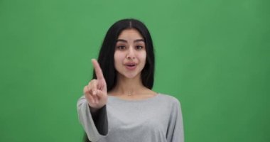 Gülümseyen kadın inkar ederek parmağını sallıyor.