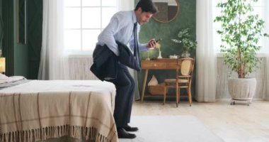 İşadamı, ofisten eve geldikten sonra cep telefonuyla kötü haber almaktan bıktı ve rahatsız oldu.
