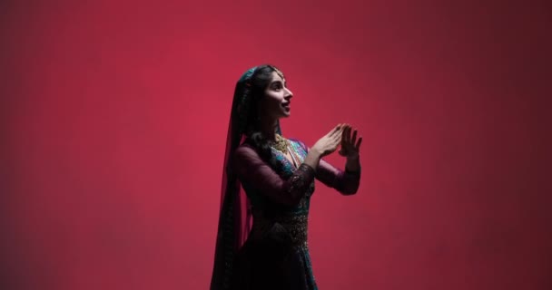 Urzekające Ruchy Indyjskiej Tancerki Hipnotyzującym Przedstawieniu Przeciwko Bogatej Czerwonej Scenie — Wideo stockowe
