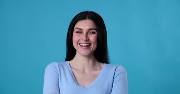 Blanke Vrouw Staat Een Blauwe Achtergrond Hardop Lachend Glimlachend Naar — Stockvideo