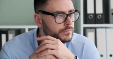 Kafkas uyruklu bir iş adamı ofisinde bir masanın arkasında oturmuş pencereden dışarı bakıyor. Yüz ifadesi, onun derin düşüncelere daldığını ve önemli konuları düşündüğünü gösteriyor..