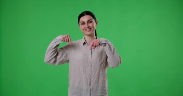 Wanita Bahagia Berdiri Atas Latar Belakang Hijau Dan Menunjuk Bawah — Stok Video