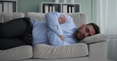 Yorgun bir Kafkasyalı ofis çalışanı kanepede uyuklarken görülüyor. Uzun bir iş günü geçirmiş gibi görünüyor ama şimdi yüzünde bir memnuniyet hissi ile huzurlu bir şekerlemenin tadını çıkarıyor..