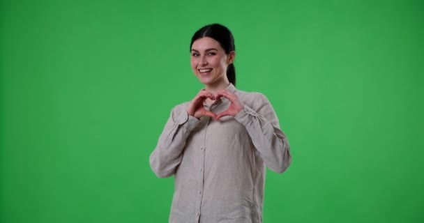 Neşeli Beyaz Kadın Yeşil Bir Perdenin Önünde Duruyor Ellerini Kalp — Stok video