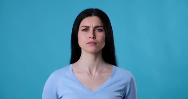 Kobieta Rasy Kaukaskiej Stoi Niebieskim Tle Patrząc Prosto Kamerę Nagle — Wideo stockowe
