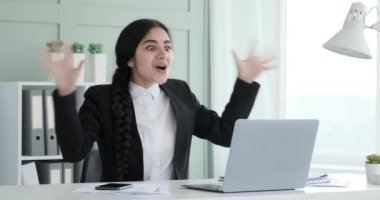 Dizüstü bilgisayarda çalışan Hintli bir iş kadını. Aniden, onu sevinç ve heyecanla dolduran harika haberler alır. Işıldayan bir gülümseme ile, iki elini havaya kaldırdı ve 