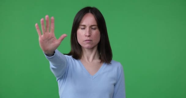 Woman Standing Green Background Extending Hand Forward Making Stop Gesture — Stock Video