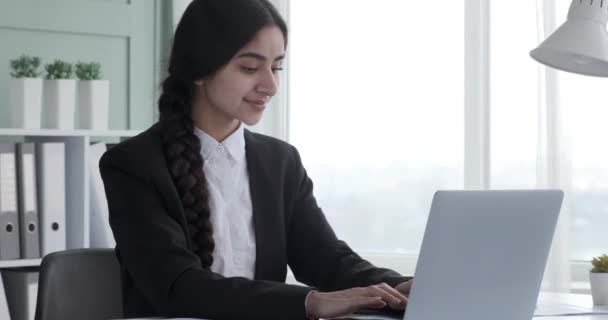 인도의한 여자는 사무실 책상에 앉아서 노트북으로 키보드를 부지런 일합니다 긍정으로 — 비디오