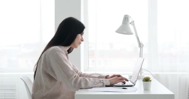 Μια Λευκή Επιχειρηματίας Κάθεται Στο Γραφείο Πληκτρολογώντας Στο Λάπτοπ Της — Αρχείο Βίντεο