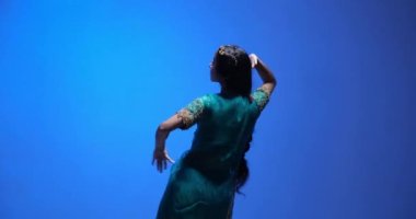 Geleneksel Bharatanatyam dansı performansı güzel bir sari ve altın mücevherle genç bir Hintli kadın tarafından. Yüzü gülüşünü ve olumlu duygularını gösteriyor..