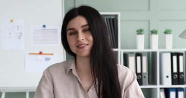 Kendine güvenen bir iş kadını video görüşmesi yapıyor, iş tecrübesini paylaşıyor ve kameraya doğru dizüstü bilgisayar kamerasıyla konuşuyormuş gibi konuşuyor. Olumlu tavrı ve çekici ses tonuyla.