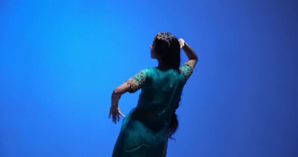 美しい景色と黄金の宝石で若いインドの民族の女性による伝統的なバラタナティヤムのダンスパフォーマンス 笑顔と肯定的な感情を示す彼女の顔 — ストック動画