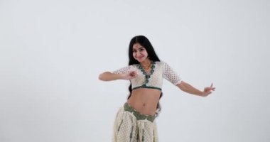 Bu genç Hintli kadın, ışıl ışıl mücevherleriyle tamamlanmış beyaz bir sari içinde geleneksel Hint dansını sergileyen bir güzellik abidesi. Zarif hareketleri ve anlamlı jestleri.